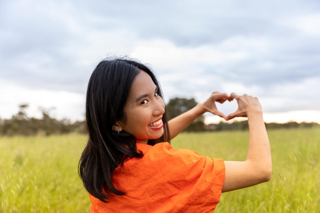 A girl draws a heart with her fingers